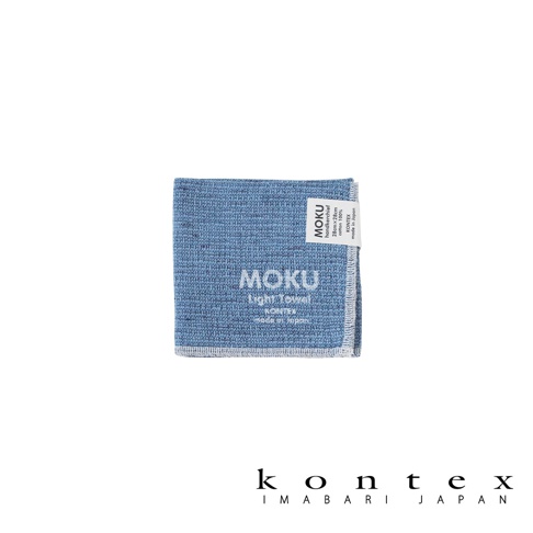 一件淺藍色、輕薄的 MOKU 小方巾，材質為 100% 純棉，尺寸為 28x28 公分。方巾上有白色縫邊，表面有細緻的織紋，並印有「MOKU Light Towel」字樣及品牌標籤。