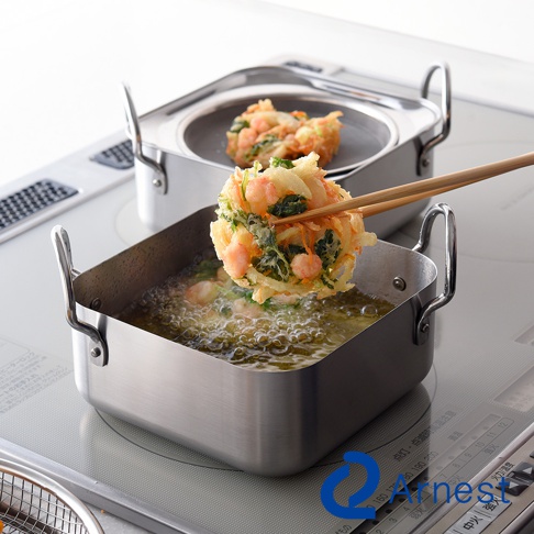 不鏽鋼方型炸物鍋內油溫沸騰，一串炸物由竹筷夾起，鍋內另有炸物置於濾油網上，整體為銀色不鏽鋼材質。