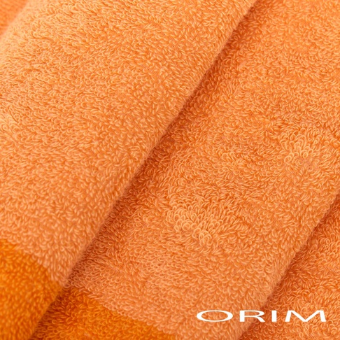 橘色拼接浴巾，材質柔軟，表面有細緻的毛圈織紋，呈現溫暖的色澤。