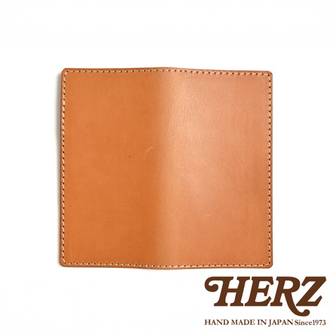 淺棕色皮革製成的輕便記事本書套，邊緣以白色車縫線勾勒，簡約設計。