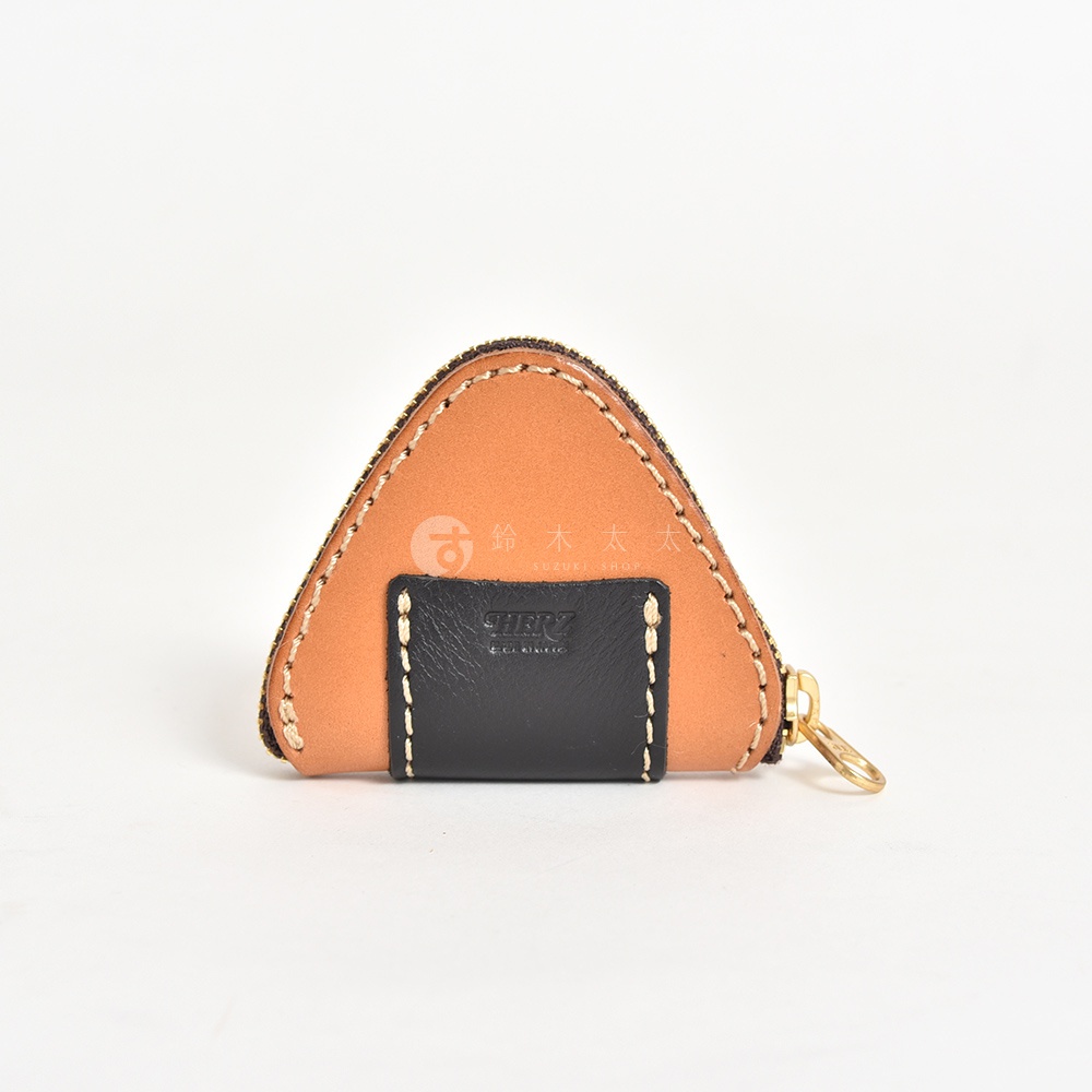 一個日本HERZ職人手作的三角飯糰造型零錢包，主體採用棕色皮革，正面拼接黑色皮革裝飾片並壓印品牌標誌，外圍縫線細緻，配有金屬拉鍊與拉環。