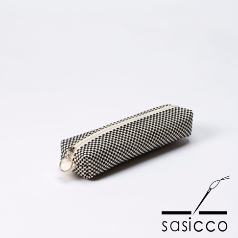 三河木綿刺子織筆袋，黑色與白色棋盤格紋，附有拉鍊與圓形拉環，置於白色背景上。