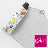 印有花鳥圖案的淺色短款傘套，內含摺疊傘，旁邊鋪著一塊淺灰色、觸感柔軟的吸水布，布料一角有銀色掛環。