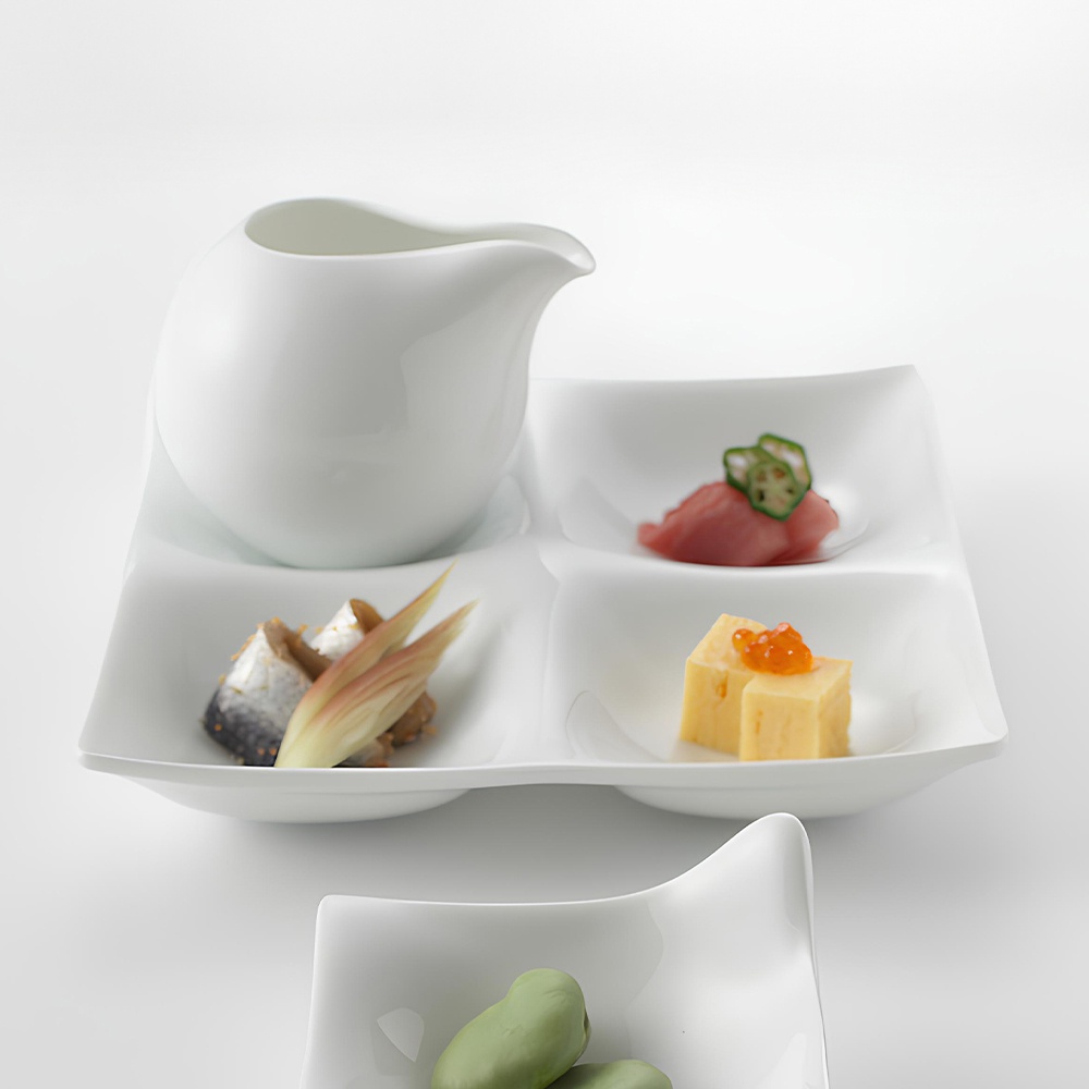 白色陶瓷四格小菜盤，附一個醬料碟，盤中盛有醃漬魚、薑片、生魚片佐秋葵，以及玉子燒佐魚卵。