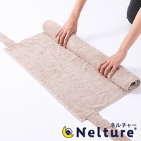 淺褐色毛巾材質的腰枕，兩側有綁帶，一人正在將其捲起。