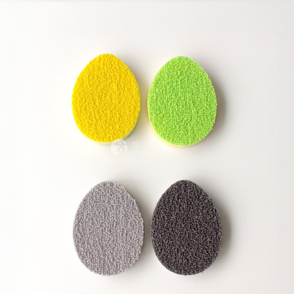 四個雞蛋形狀的菜瓜布，有黃色、綠色、灰色和深灰色。
