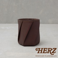 職人手作皮革Organ六角收納筆筒，深棕色皮革，以交錯的皮革片彎曲成六角形狀，邊緣有縫線處理，簡潔實用。