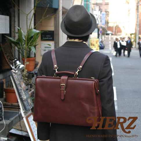 職人手作皮革軟式杜勒斯包，深棕色，帶有金色金屬釦環與揹帶。