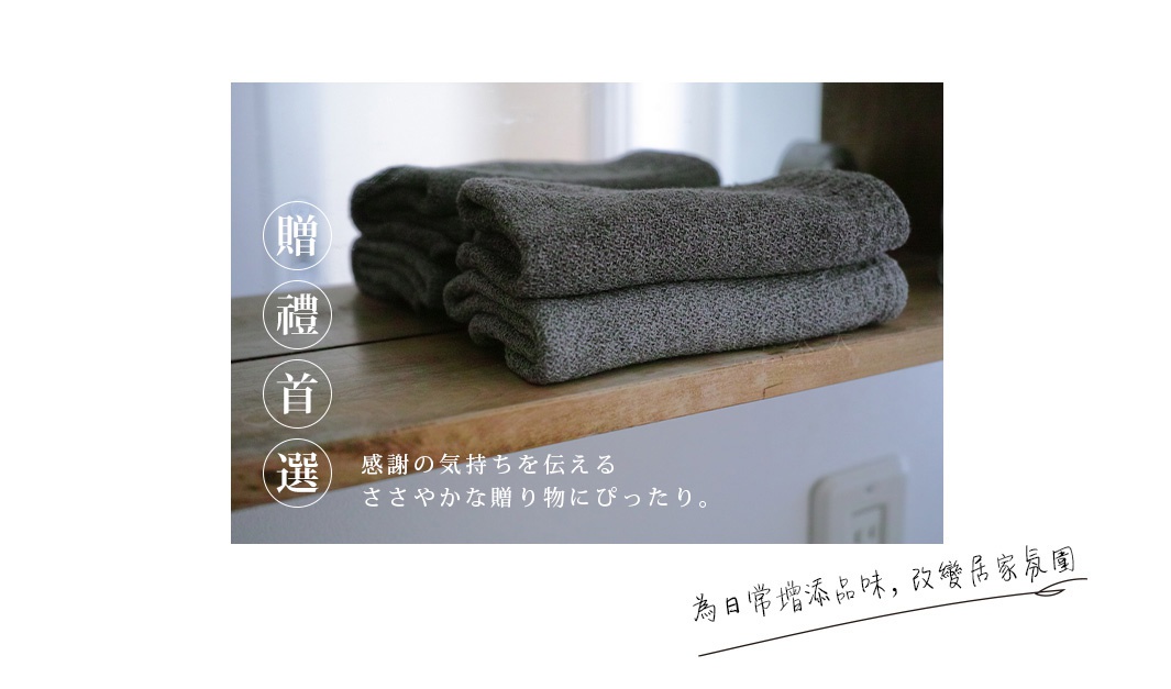 疊放的深灰色針織風純棉浴巾，質地柔軟，紋理清晰。