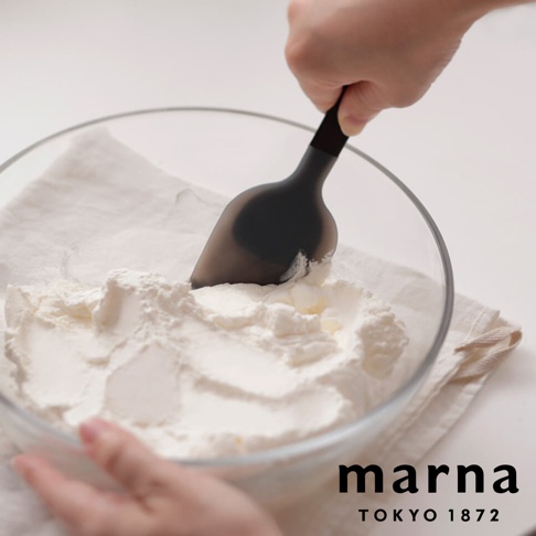 marna TOKYO 1872 品牌字樣，搭配一只手正在使用黑色三角耐熱矽膠料理刮刀在裝有白色粉末的透明玻璃碗中攪拌