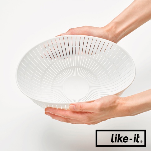 雙層白色塑膠瀝水籃，邊緣有放射狀的細長孔洞，中央為較大的圓形凹陷，由雙手捧持。