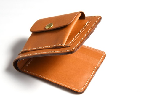 焦糖色皮革雙折短夾，外附零錢袋，附有黃銅按扣，車縫線為白色。