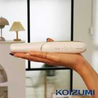 一支手拿著白色珍珠離子夾，離子夾上有金色的邊框和控制按鈕，以及KOIZUMI的品牌標誌