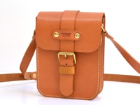 職人手作皮革經典皮扣單肩包，採用天然棕色皮革，帶有金色皮扣和鉚釘，設計簡潔，適合日常攜帶。