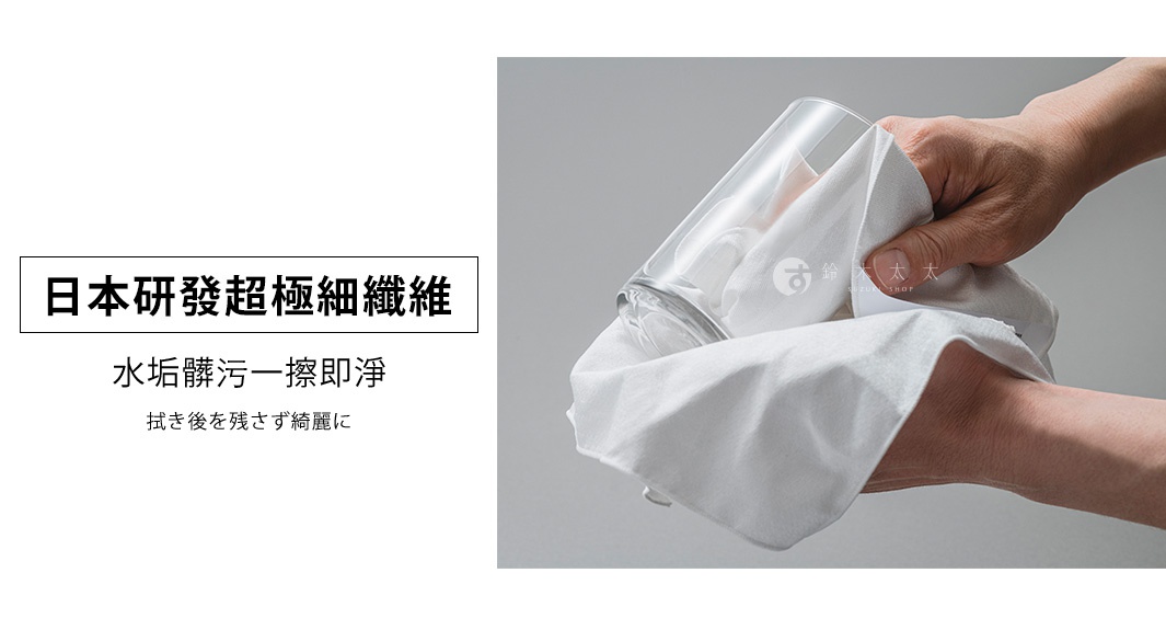 一隻手拿著白色超細纖維擦拭巾，擦拭一個玻璃杯。