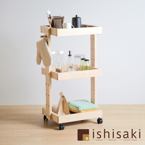 淺木色三層收納推車，頂層擺放餐具、咖啡壺與杯子，中層有玻璃瓶罐與調味品，底層有紙袋及毛巾，推車側邊懸掛隔熱手套，底部配有黑色輪子。
