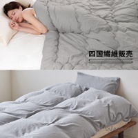 模式B： 一位女子側臥在鋪著灰色被子的床上，畫面下方展示了疊放整齊的灰色被子和枕頭。