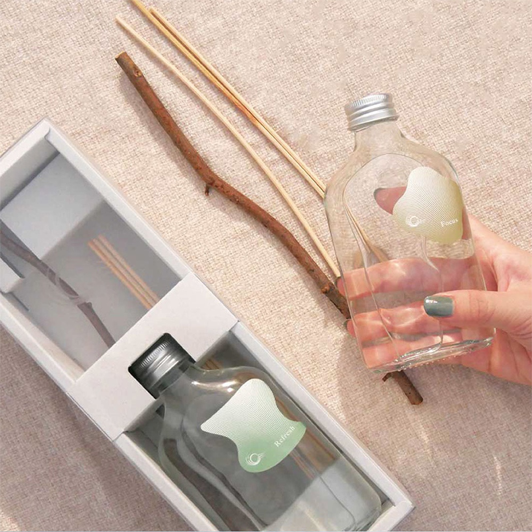 KYARA aroma recolte diffuser 室內擴香竹，包含兩瓶不同香氛的擴香瓶，一瓶標示「Refresh」，另一瓶標示「Focus」，周圍擺放著幾根擴香竹和一根樹枝。