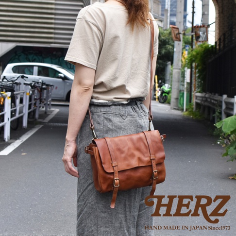 職人手作皮革復古郵差包，採用鞣製皮革製成，散發自然光澤，配有可調式肩帶和金屬釦環。