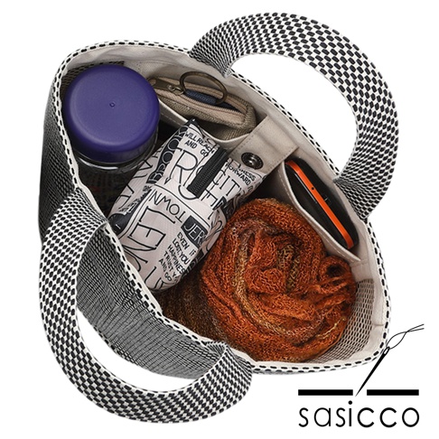 三河木綿刺子織圓底水桶包，黑白格紋織紋，內部裝有紫色瓶蓋的罐子、印有文字的白色收納包、鑰匙零錢包、橘色手機及橘色毛線織品。