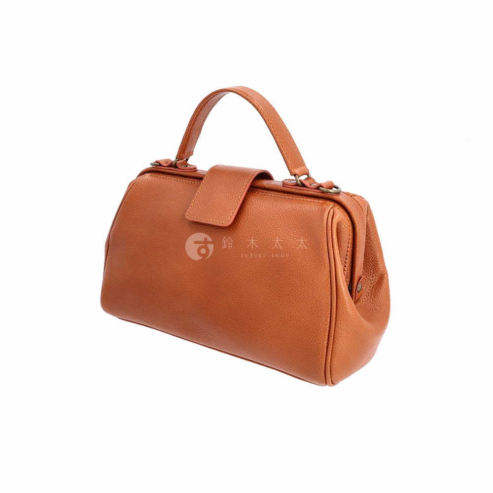 一個橘棕色皮革的迷你手提包，具有經典的醫生包造型，包身呈現圓潤的曲線，搭配單提把和旋轉鎖扣，包面上印有日文和英文的品牌標誌