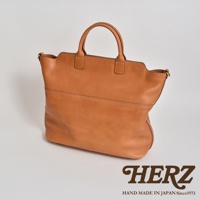 棕褐色皮革製成的大容量兩用托特包，包身線條簡潔，設有提把與雙邊肩帶，皮革表面有自然的紋理與縫線細節。