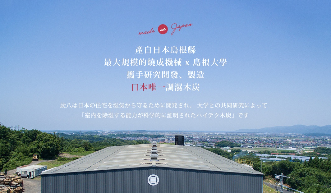 圖片文字：產自日本島根縣，透過最大規模的燒成機械與島根大學攜手研究開發製造，為日本唯一調濕木炭。炭八是為了保護日本住宅免受濕氣侵害所開發，透過與大學的共同研究，證實具備科學除濕能力的產品。圖片背景為廣闊的藍天，下方為一棟工廠建築，並襯有綠意盎然的遠景，上方印有 made in Japan 標誌。