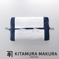 昭和懷舊可調式綁帶復古枕，深藍色布料帶有細小格子圖案，表面有兩層白色布料，下方白色布料有兩個白色細繩綁結，兩側有藍色繩圈。