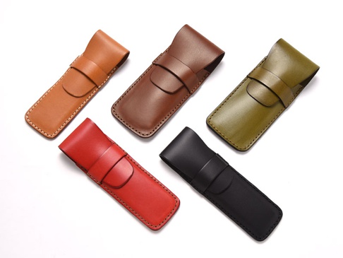 五款皮革鋼筆收納筆套，顏色包含：淺棕、深棕、墨綠、紅色、黑色。筆套皆為皮革材質，長方形設計，頂部有翻蓋式束帶。