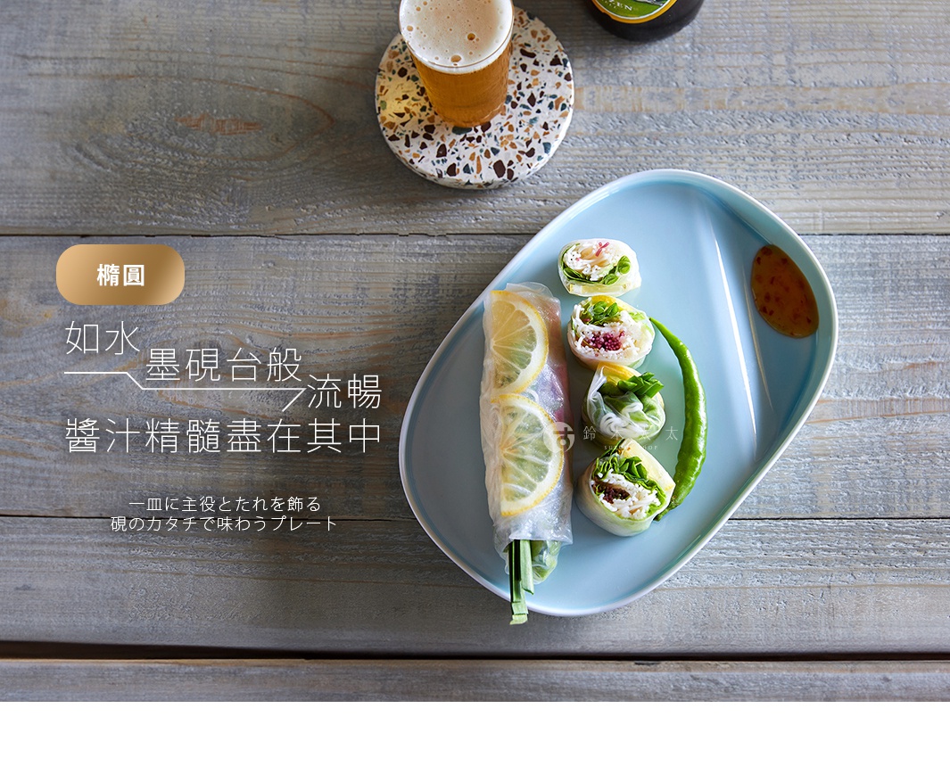 淺藍色波佐見燒橢圓主菜盤，盤中盛有兩卷米紙春捲，其中一卷切片，盤緣另有醬汁。