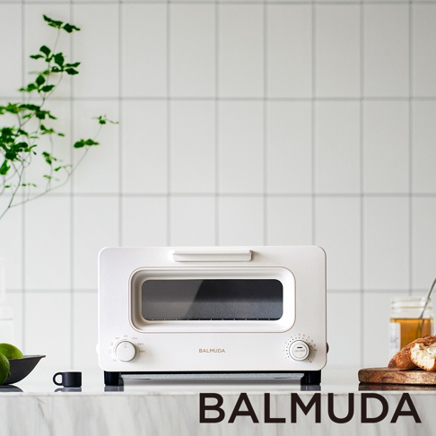 The Toaster 蒸氣烤麵包機 (白色) 採用簡潔的白色外觀，配備寬大的玻璃觀察窗和兩個操作旋鈕。機身線條流暢，材質應為金屬與塑膠結合，整體呈現現代廚房家電的設計風格。