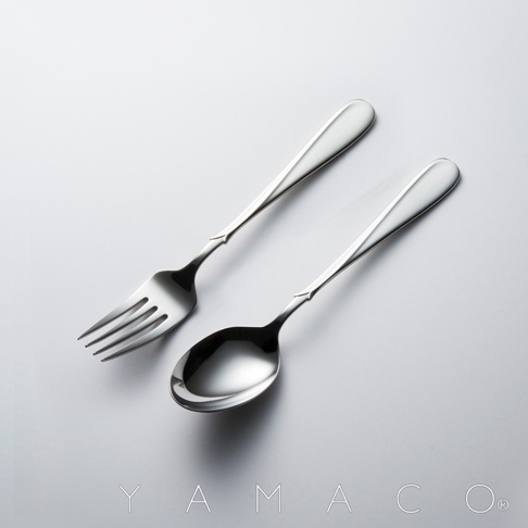 Flora系列不鏽鋼叉匙兩件組，銀色金屬材質，叉子有四齒，湯匙為圓弧狀，兩者手柄處皆有細緻的裝飾線條，整體呈簡約優雅的設計風格。