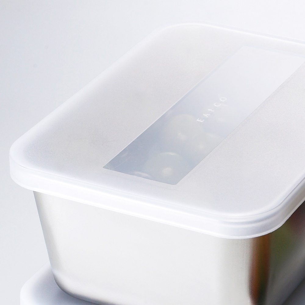 日製不鏽鋼食物儲存盒，配有半透明白色塑膠蓋，蓋子中央設有透明觀察窗，窗上印有「EATCO」字樣。