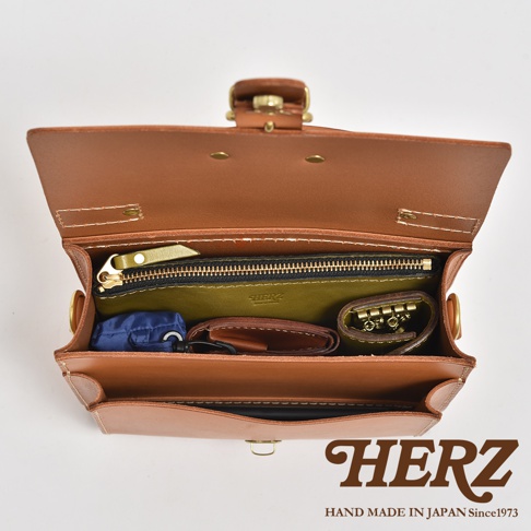 職人手作皮革經典混合風迷你單肩包，棕色皮革材質，內有綠色內襯拉鍊袋、鑰匙圈、錢包等物品。