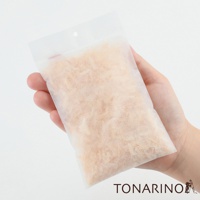 一隻手拿著一個半透明的白色防潮消臭檜木除濕包，包內裝滿了淺棕色的檜木碎屑。