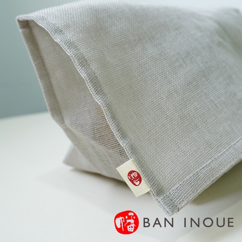 灰色的蚊帳布透氣蔬果收納袋，材質輕薄網狀，帶有品牌標籤，適合收納蔬果。