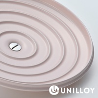 淺粉色琺瑯鑄鐵鍋鍋蓋，鍋蓋表面有同心圓紋路，中央設有銀色金屬把手。