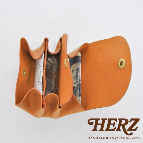 職人手作皮革三層收納零錢包，橘棕色皮革，內部收納有日圓紙鈔與硬幣，設計簡約實用。