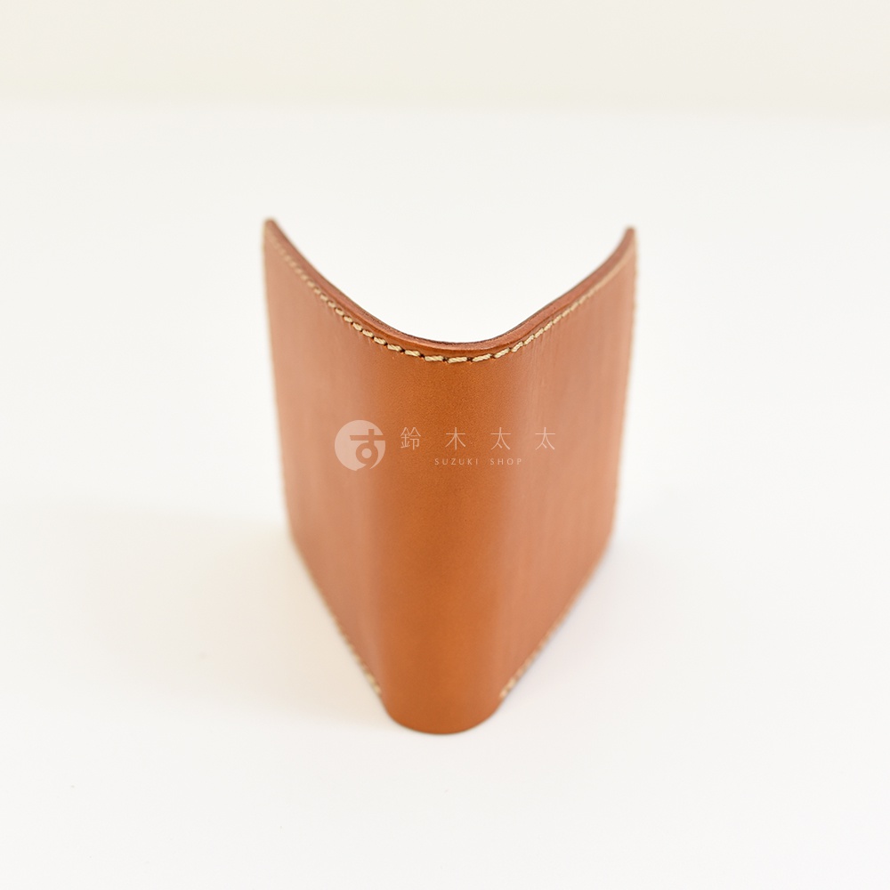 淺棕色皮革製成的二折橫式短夾，側邊縫線清晰可見，展現職人手作質感。