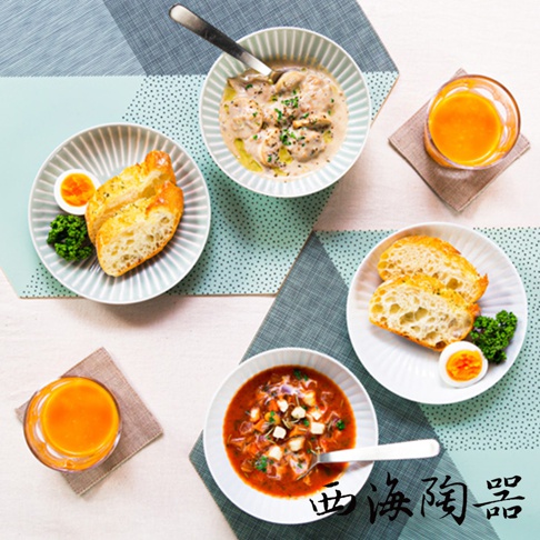 波佐見燒花紋陶瓷碗盤組，包含盛有雞肉奶油燉菜的碗、盛有麵包和水煮蛋的盤子、以及裝有蔬菜湯的碗，搭配柳橙汁，整體色調柔和。