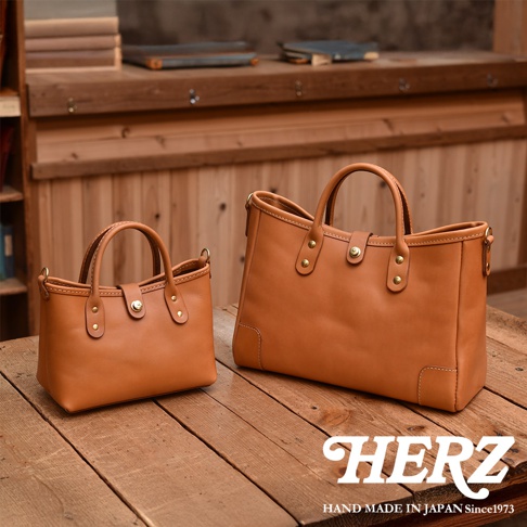兩款職人手作皮革迷你托特包，皆為淺棕色，材質為真皮，造型簡約，配有提把與金屬釦。