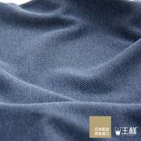 藍色織紋枕套，材質細緻，帶有細小的網狀紋理，布料表面平整，部分區域有自然的皺褶，左下角有品牌標誌與日文說明。