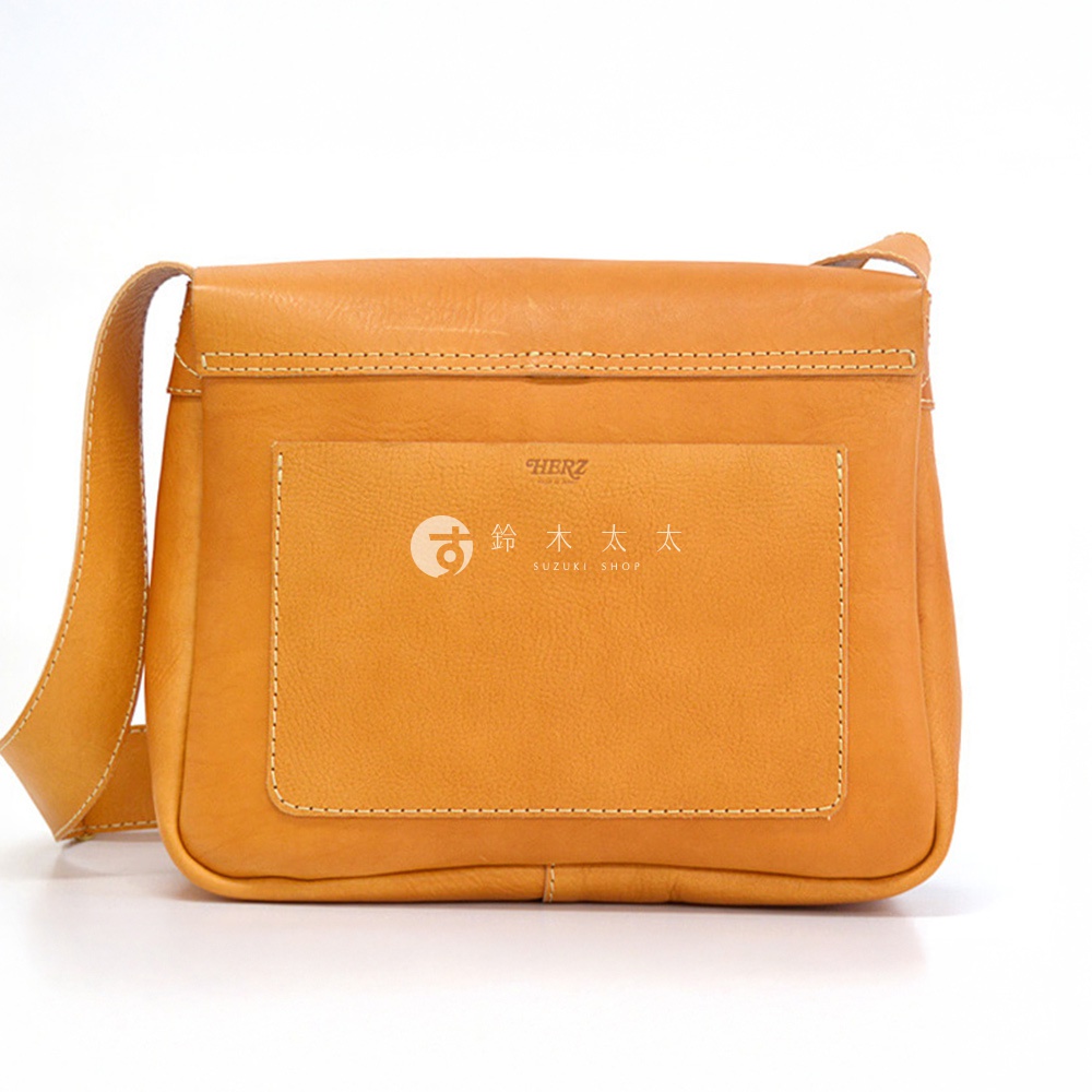 日本HERZ職人手作皮革軟皮橫式斜背包，橘黃色皮革包身設有外袋，袋面印有品牌標誌及文字。
