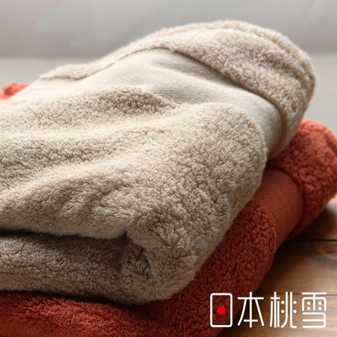 疊放的兩條今治匹馬棉浴巾，上方為米色，下方為橘紅色，質地柔軟蓬鬆，紋理清晰可見。