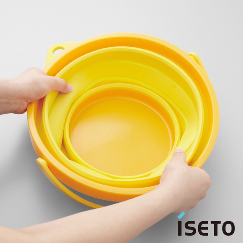 黃色伸縮旅行水桶，由兩層塑膠材質製成，兩側有提把，可折疊收納。
