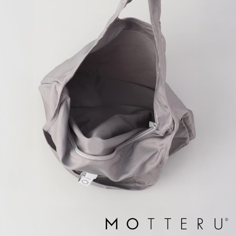 一個銀灰色的可折疊托特袋，採用尼龍材質，頂部開口有拉鍊，內部空間寬敞，袋身上有白色品牌標籤。