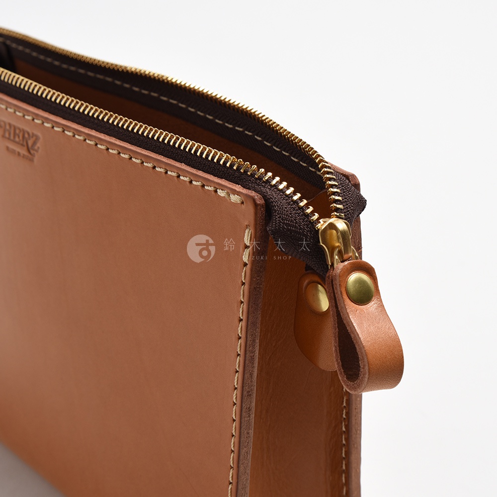 棕色皮革手拿包，配有深棕色拉鍊和金色拉鍊頭，以及皮革拉環和金色金屬釦。