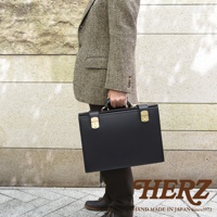 職人手作皮革機師箱 BC-31，黑色光滑牛皮材質，配有金色鎖扣和手柄，適合商務人士。