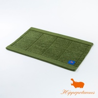 綠色竹棉混紡厚感浴墊，表面有方格紋理，一角有藍色標籤，標有橘色河馬圖案和品牌名稱。