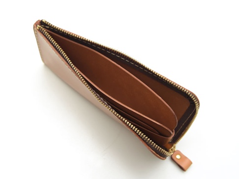 職人手作皮革L型拉鍊長夾，採用溫潤的棕色皮革製作，配有復古黃銅色拉鍊，內層結構清晰可見，展現其簡約實用的設計。